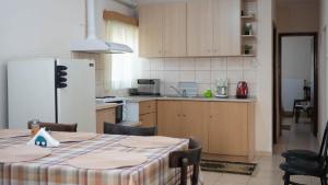 a kitchen with a table and a white refrigerator at Garden Paradise in Megalochori Trikala in Tríkala