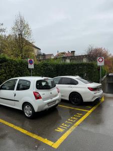 two white cars parked in a parking lot at tas24ch Travel and Sleep 24 in St. Gallen