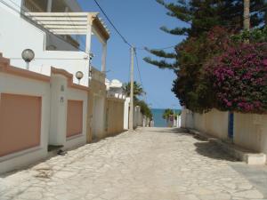 an empty street with flowers on the side of a building at Villa Azaiiza in Sousse