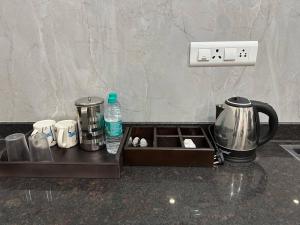 a kitchen counter with a tray with pots and pans at Passaddhi Serviced Apartment F2 in Mysore