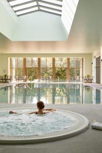 una persona en una bañera en una piscina en The Lodge at Ashford Castle, en Cong