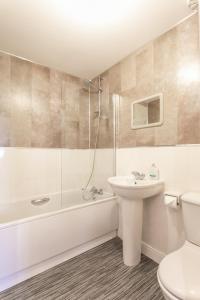 a bathroom with a sink and a tub and a toilet at The Durham House in Leyland