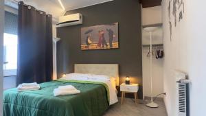 ローマにあるRome Apartment with terrace Autonomousのベッドルーム1室(ベッド1台付)が備わります。壁には絵画が飾られています。