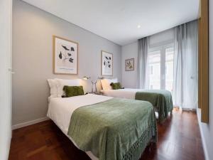 1 Schlafzimmer mit 2 Betten und grünen Decken in der Unterkunft Olaias Lisbon 2 bed near Metro 2 in Lissabon