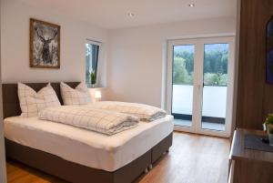 a bedroom with a large bed and a window at Mountain View Appartements mit Blick WIESENBLICK in Innsbruck