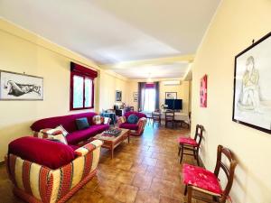 a living room with couches and a table and chairs at Villa Giada in Carini