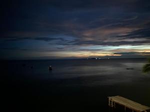 uma vista para um corpo de água à noite em Las Palmeras OceanView Hotel and Dive Center em Corn Island