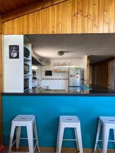 um balcão azul numa cozinha com dois bancos em Casa en Santiago equipada em Santiago
