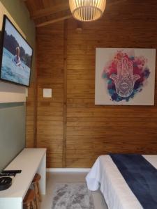 a bedroom with wooden walls and a bed and a television at Morada Bem Me Quer in Canela