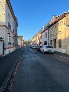 uma rua vazia com carros estacionados de lado em Ravissant T2 proche centre-ville et Jard em Châlons-en-Champagne