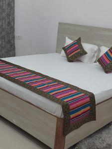 a bed with colorful blankets and pillows on it at 5 PETALS in Varanasi