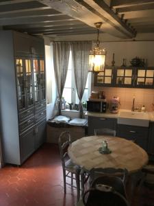 a kitchen with a table and chairs and a kitchen with a tableablish at Casa romantica in Chaussy