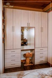 a large wooden cabinet with a bench in a room at Quinta maría isabel. Elegante y restaurada in Gualaceo