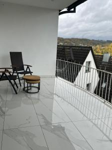 eine Terrasse mit 2 Stühlen und einem Tisch auf dem Balkon in der Unterkunft Zimmer Orange mit Weitblick und Sauna in Sundern
