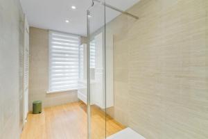 a glass shower in a bathroom with a window at Seaside 27 - De perfecte familie vakantiewoning aan zee voor 10p in Blankenberge