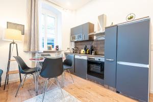 een keuken met een tafel en stoelen in een kamer bij LiT LiVING: Luxus - Box SprIng - WH Old Town in Weinheim