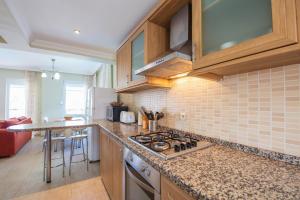a kitchen with wooden cabinets and a stove top oven at Golden Trio Villa in Oludeniz
