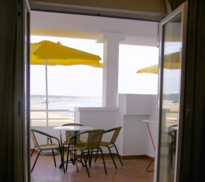 una sala da pranzo con tavolo, sedie e ombrelloni di Apartments Kepi Gjerana a Ulcinj Altre 33 foto