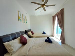 a bedroom with two beds and a ceiling fan at MansionOne Gleneagles Superb Seaview 8pax 2Bedrooms 1Bathroom By AmrayHomes in George Town
