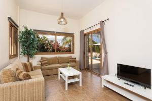 a living room with a couch and a tv at Villa Windmill in Polis Chrysochous