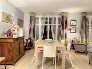 een woonkamer met een eettafel en stoelen bij Paris Porte d'Auteuil 2 BR Apartment in Parijs