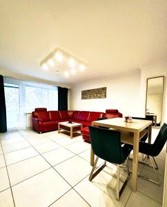 uma sala de estar com um sofá vermelho e uma mesa em HomeZone Seelze em Seelze