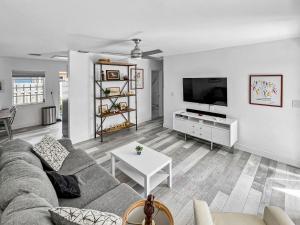 uma sala de estar com um sofá e uma televisão em Tropical 2-Bedroom 1-Bath Private Key West-like Home Close To Beach em Pompano Beach