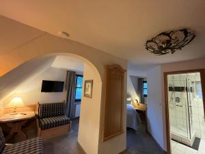 Hotel zum Forsthaus في فيلنغن: غرفة نوم فيها سرير وثريا