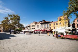 a town square with people sitting on benches and buildings at Santa Margherita, casa accogliente e confortevole in Venice