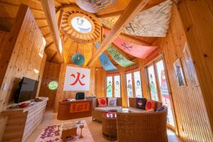 ein Wohnzimmer mit einer großen Holzdecke und einer Uhr in der Unterkunft GRAND CHARIOT Hokutoshichisei 135° in Awaji