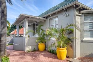 a house with two large yellow pots in front of it at Hampton Collection - Charming 1 or 2 Bedroom Serviced Apartment with Pool in Durban