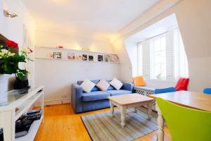a living room with a blue couch and a table at Roof Terrace Flat in Hampstead Pass The Keys in London