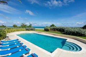 a swimming pool with lounge chairs and the ocean at Belair Great House - The stunning, private escape with breathtaking views and exquisite surroundings. in Saint Philip