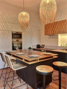 una cocina con una mesa con sillas y luces en Le Divio - Homillesime, en Dijon