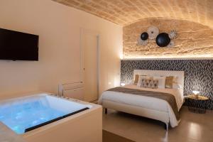 a bedroom with a bed and a tub at B&B Torre Canina suite & rooms in Trani