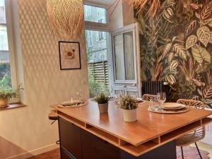 a dining room with a table with glasses and plants at Le Divio - Homillesime in Dijon