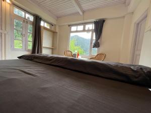 a large bed in a room with a large window at Odin Hostel Shoja in Shoja