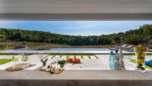 einen Tisch mit Speisen und Weingläsern auf einer Terrasse in der Unterkunft Luxury Villa Depollo in Donji Vinjani