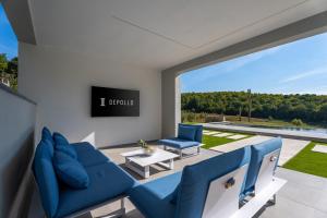 ein Wohnzimmer mit blauen Möbeln und einem großen Fenster in der Unterkunft Luxury Villa Depollo in Donji Vinjani