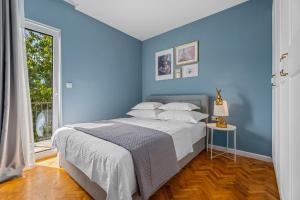 a blue bedroom with a bed and a window at Luxury Villa Depollo in Donji Vinjani +63 photos