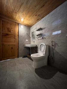 a bathroom with a toilet and a sink at Odin Hostel Shoja in Shoja