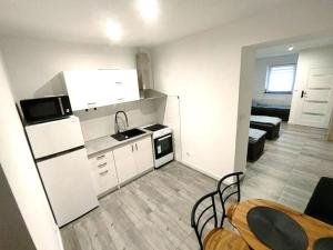 a kitchen with a refrigerator and a table and chairs at Apartamenty Barlinek in Barlinek