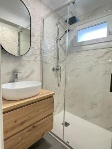 a bathroom with a sink and a glass shower at Apartamentos 2K - Apartamento en playa de Brazomar reformado in Castro-Urdiales