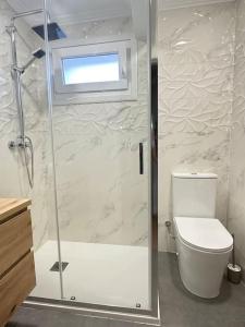 a bathroom with a shower with a toilet and a window at Apartamentos 2K - Apartamento en playa de Brazomar reformado in Castro-Urdiales