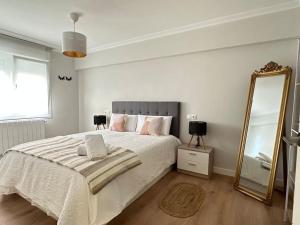 a bedroom with a large bed and a mirror at Apartamentos 2K - Apartamento en playa de Brazomar reformado in Castro-Urdiales +10 photos