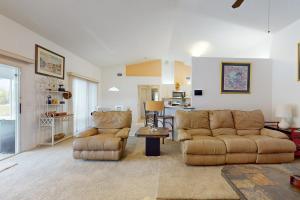 a living room with two couches and a table at Palm Bay Getaway in Palm Bay