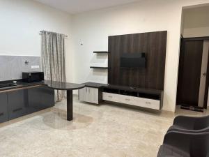 a living room with a table and a flat screen tv at Passaddhi Serviced Apartment G1 in Mysore
