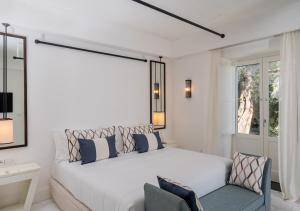 - une chambre blanche avec un grand lit et une fenêtre dans l'établissement Furore Grand Hotel, à Furore