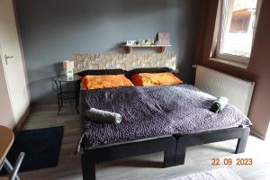 um quarto com uma cama com um edredão roxo em Páfrány Vendégház em Szálka