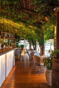 a restaurant with a bar with chairs and plants at Casas Brancas Boutique Hotel & Spa in Búzios